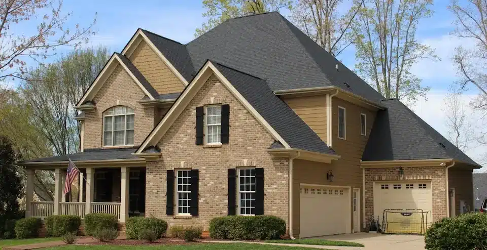 Two-story brick and siding house with a combination of hip and gable roofs