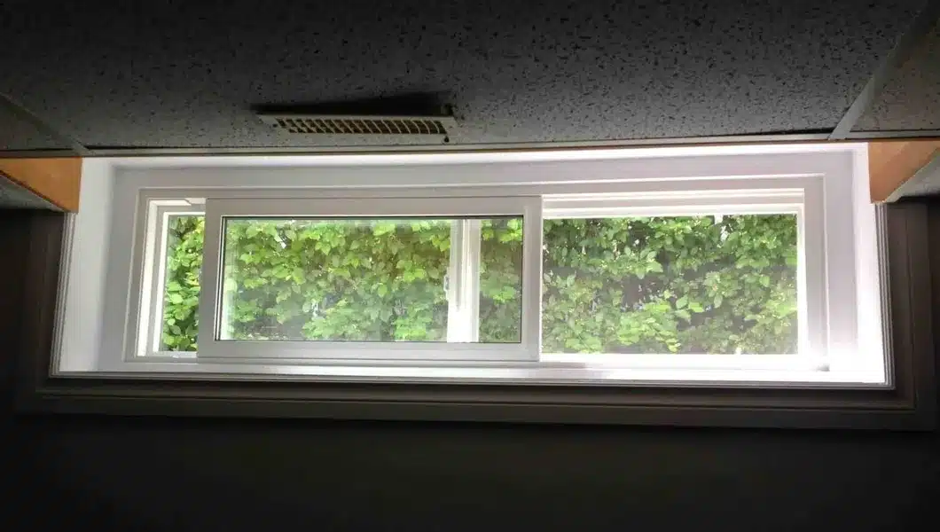 Horizontal sliding egress window in a finished basement providing natural light and ventilation