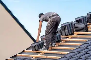 Roofer working in protective work wear gloves,