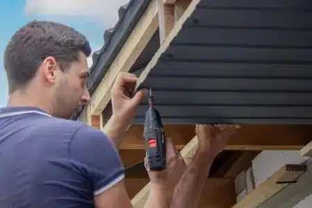 Man repairing metal roofing East Providence