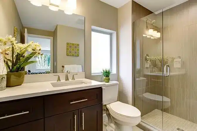 Modern small bathroom with glass shower, single vanity, and neutral tones