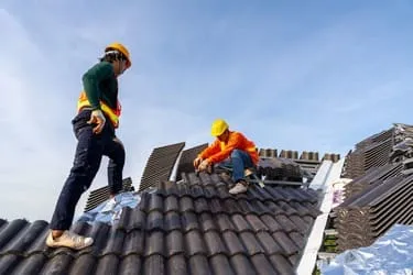 Team fixing tiled roof using power tools roofing Bristol service-