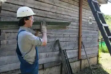 Worker carrying siding planks for renovation Siding East Providence