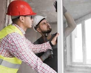 Worker cleaning tall windows in a modern apartment for home renovation Bristol service