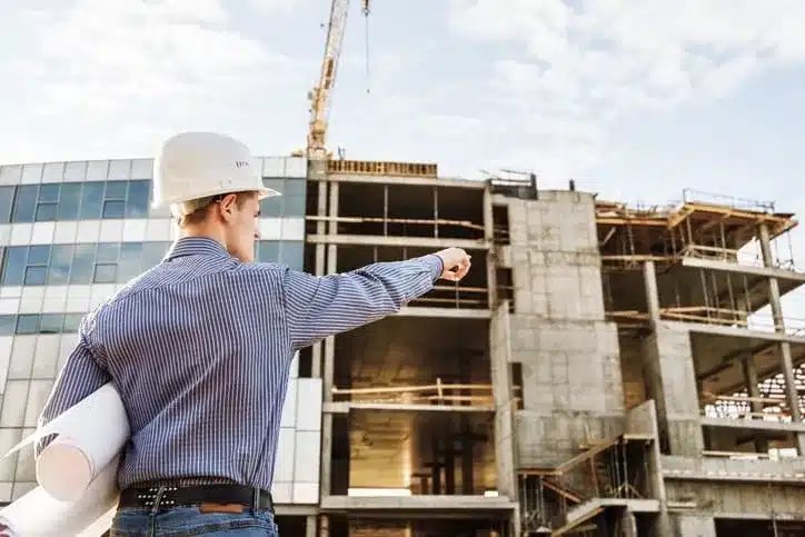 construction consultant pointing toward a building