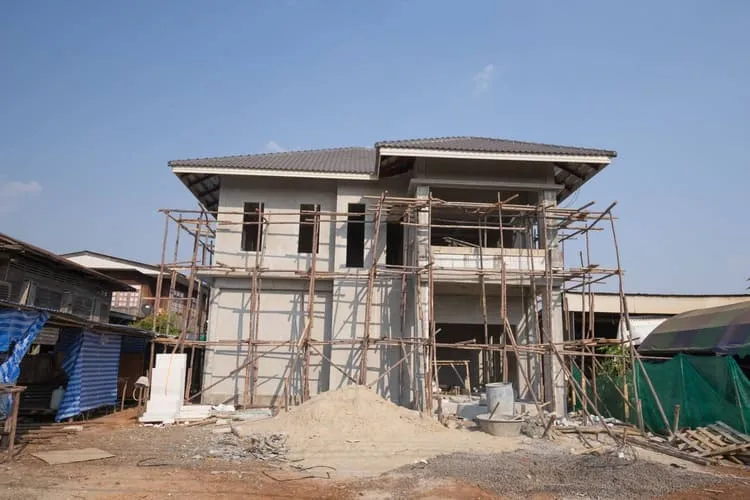 Single-family home in Providence under construction, showing exterior scaffolding, a partially completed structure, and scattered building materials on-site.