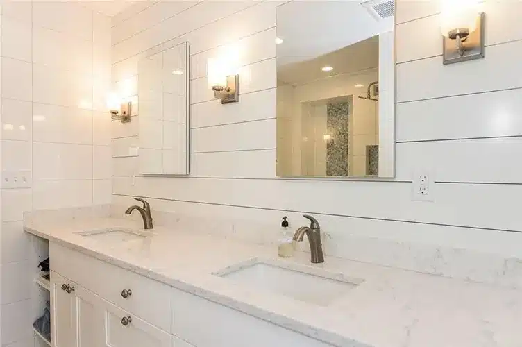 Modern double-sink vanity with marble countertop in custom bathroom remodel.