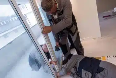 carpenters installing a balcony door in providence