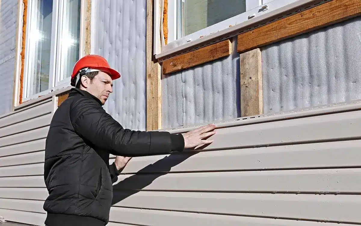 A pro worker installing siding panels