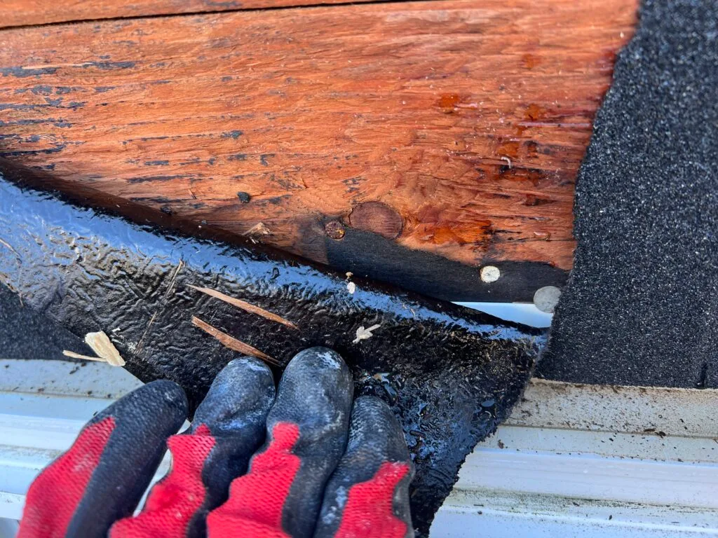 Rotted roof decking exposed at a failed flashing detail.
