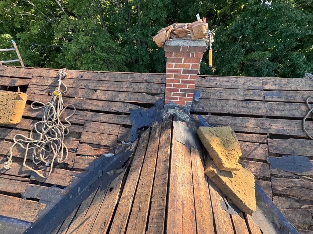 Chimney flashing being rebuilt during a roof replacement.